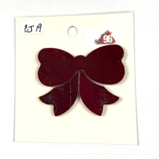 Dark red bow-shaped craft cutout mounted on white card stock with a circular hole at the top and a small CJ 19 label in the corner.